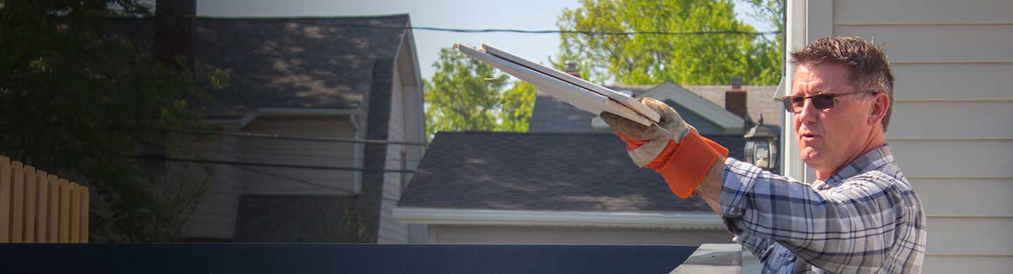 man throwing building materials into a short term dumpster rental