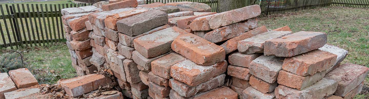 A close-up of a stack of old bricks in someone's yard.