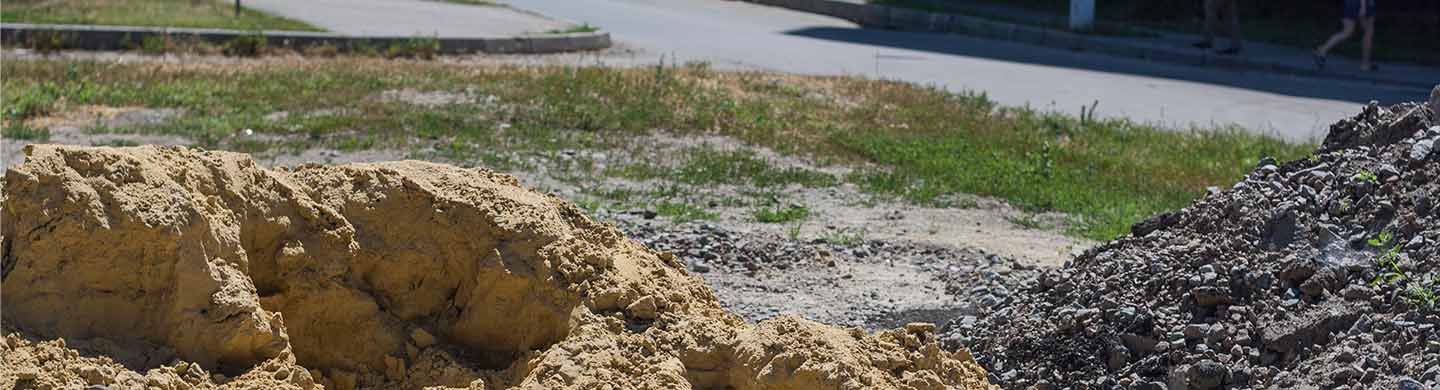 Two piles of dirt sitting on the ground. 