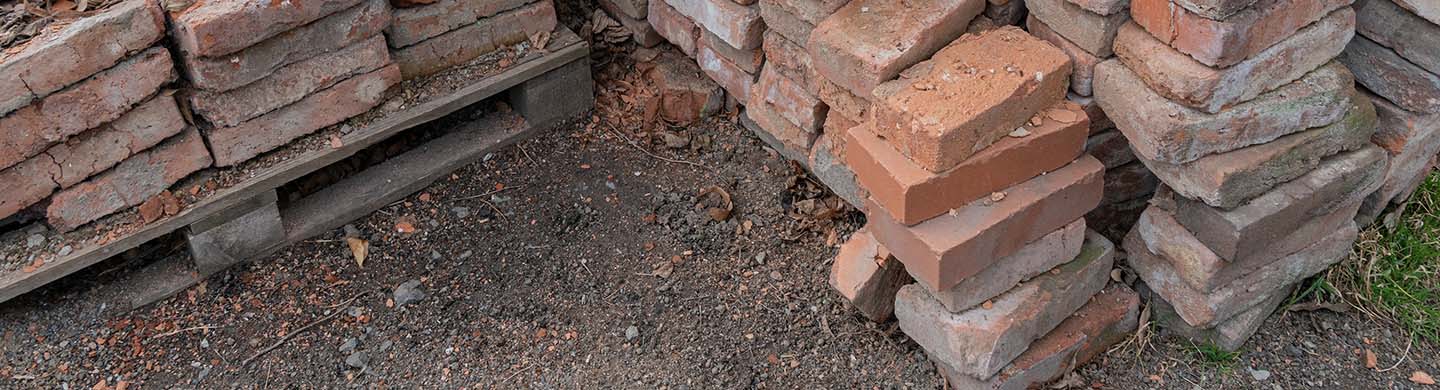 A close-up of a stack of old bricks in someone's yard.