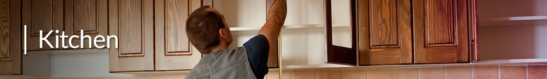 A Contractor Measuring Cabinets for a Kitchen Remodel.