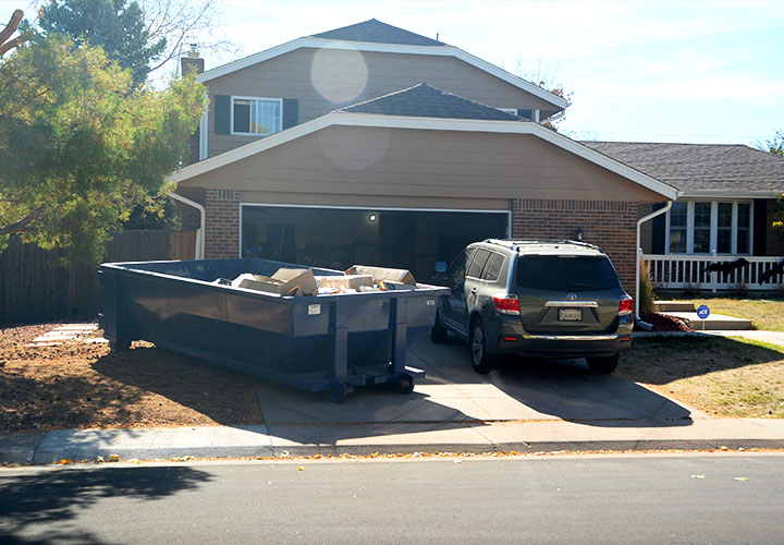 Roll Off Dumpster in Residential Driveway Near House and SUV.