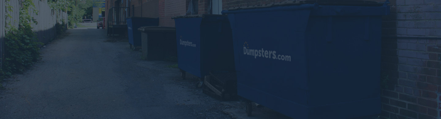 Three Front Load Dumpsters in Alley.