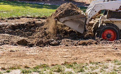 Compact excavator removing dirt. 