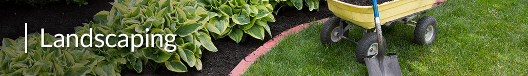 Wagon of Mulch and Shovel Next to a Garden.