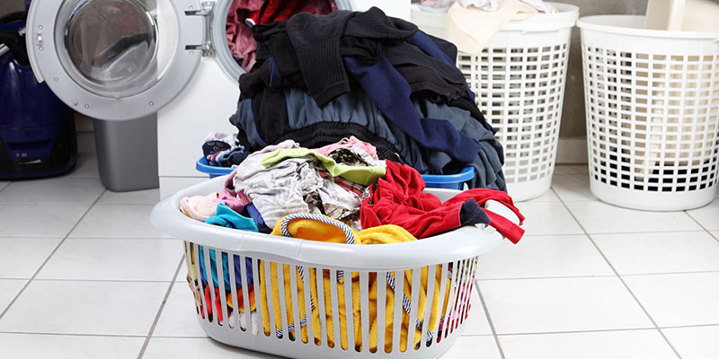 Overflowing laundry basket on white tile floors