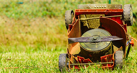 A Lawnmower in the Grass Upside Down.