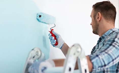 Man rolling paint onto wall. 