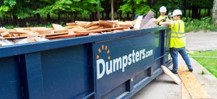 Two Construction Workers Filling a Roll Off Dumpster with Wood.