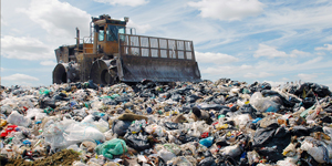 Bulldozer mashing down debris in a landfill