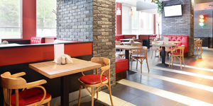 inside of a restaurant franchise with red walls and seats