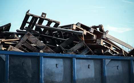 A house with a roll off dumpster in the driveway. 