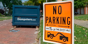 no parking sign with a dumpsters.com bin in the background