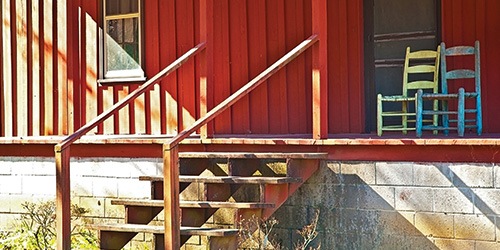 Old porch with wooden steps and cinderblock foundation.
