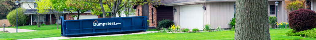 Roll Off Dumpster in Driveway with Green Lawn.