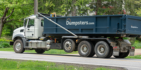 roll off dumpster truck driving down the road