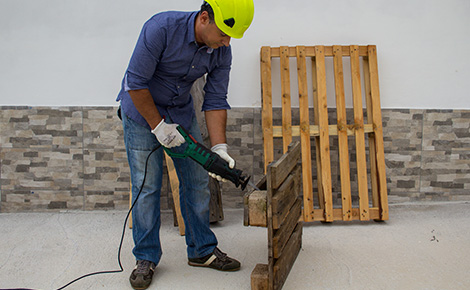 A worker repairing an old pallet.