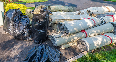 Carpet and Other Remodeling Debris Piled in a Driveway.