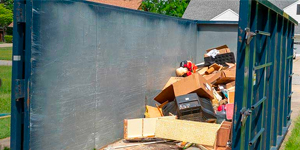 A 40 yard roll off dumpster partially filled with debris.