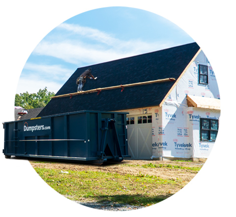 a roofer working on a new roof near a dumpsters.com roofing debris bin