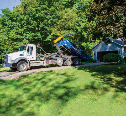 a truck picking up a roll off dumpster