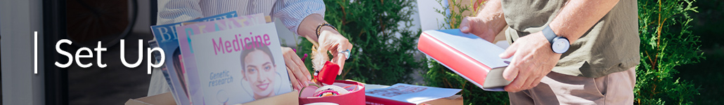 People Looking Through Books and Boxes of Items at Garage Sale.