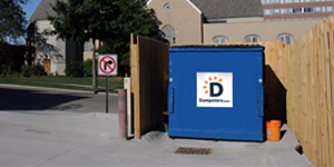 Dumpsters.com Front Load Dumpster Inside a Fenced-Off Area