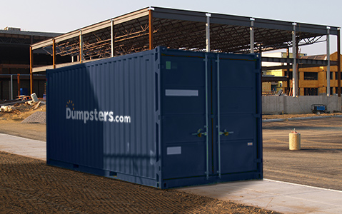 A blue Dumpsters.com storage container on a jobsite in front of a partially constructed building.
