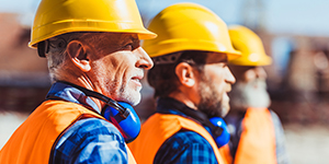 Three Construction Workers With Yellow Hard Hats.