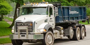 Truck Driving With Roll Off Dumpster.