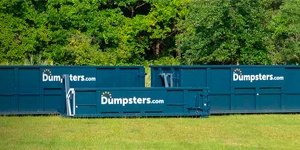 Various Dumpsters.com roll off dumpster sizes on a field of green grass.