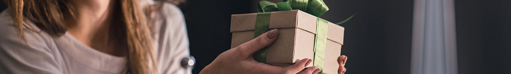 Woman Holding a Box Wrapped in a Green Bow.