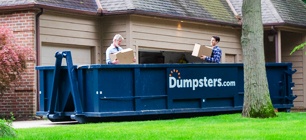 Two Men Loading a Roll Off Dumpster.