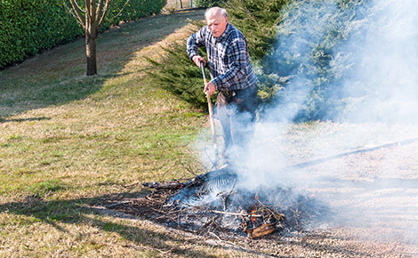 Man Burning Brush in an Open Space.